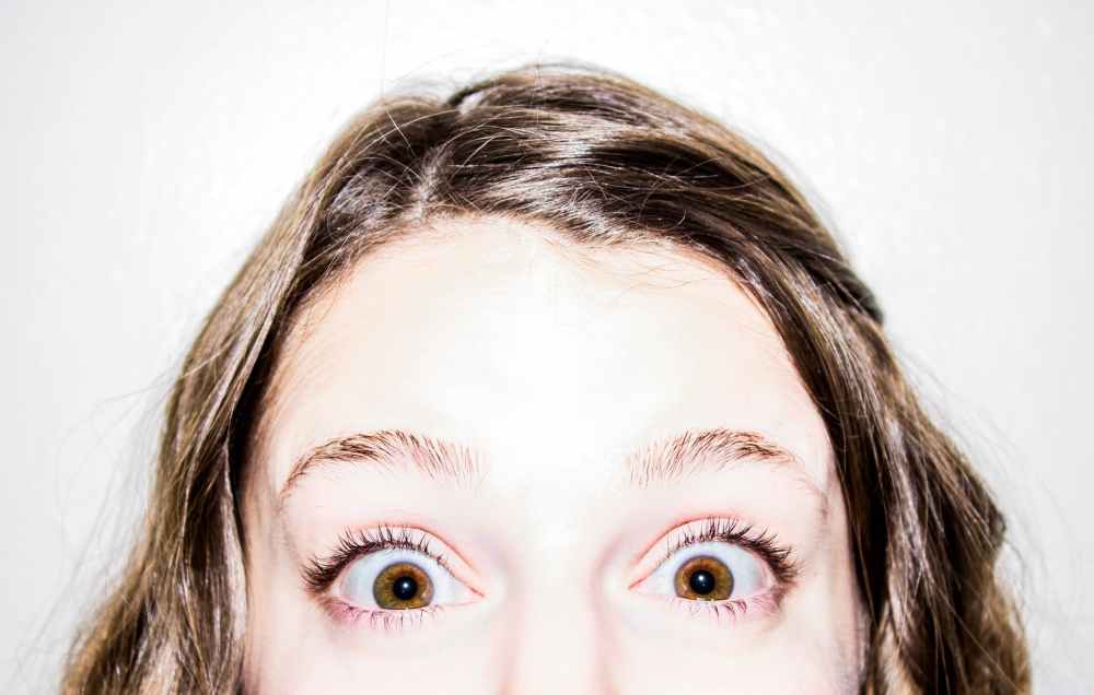 Girl with a shocked look on her face and brown hair. Photo by pexels.com