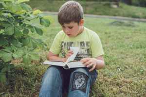 Boy reading. Photo by Tanya Gorelova via pexels.com.