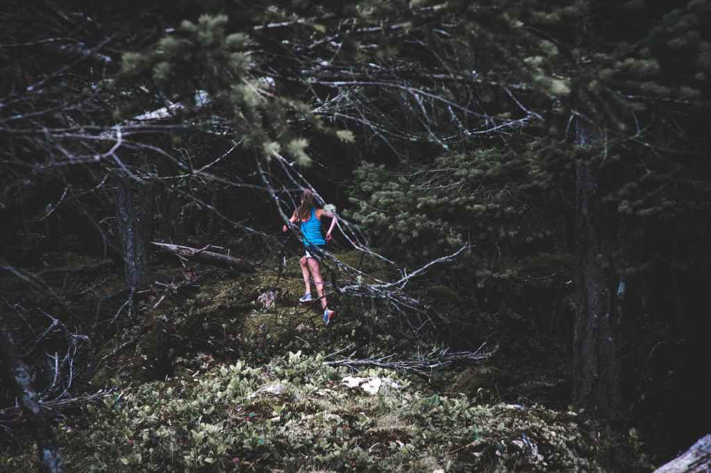 photo courtesy pexels.com (photographer Anthony Moore). Image shows a child in a blue shirt and shorts running through a forest Photo courtesy Anthony Moore at pexels.com. Image shows a child in a blue shirt running through a forest