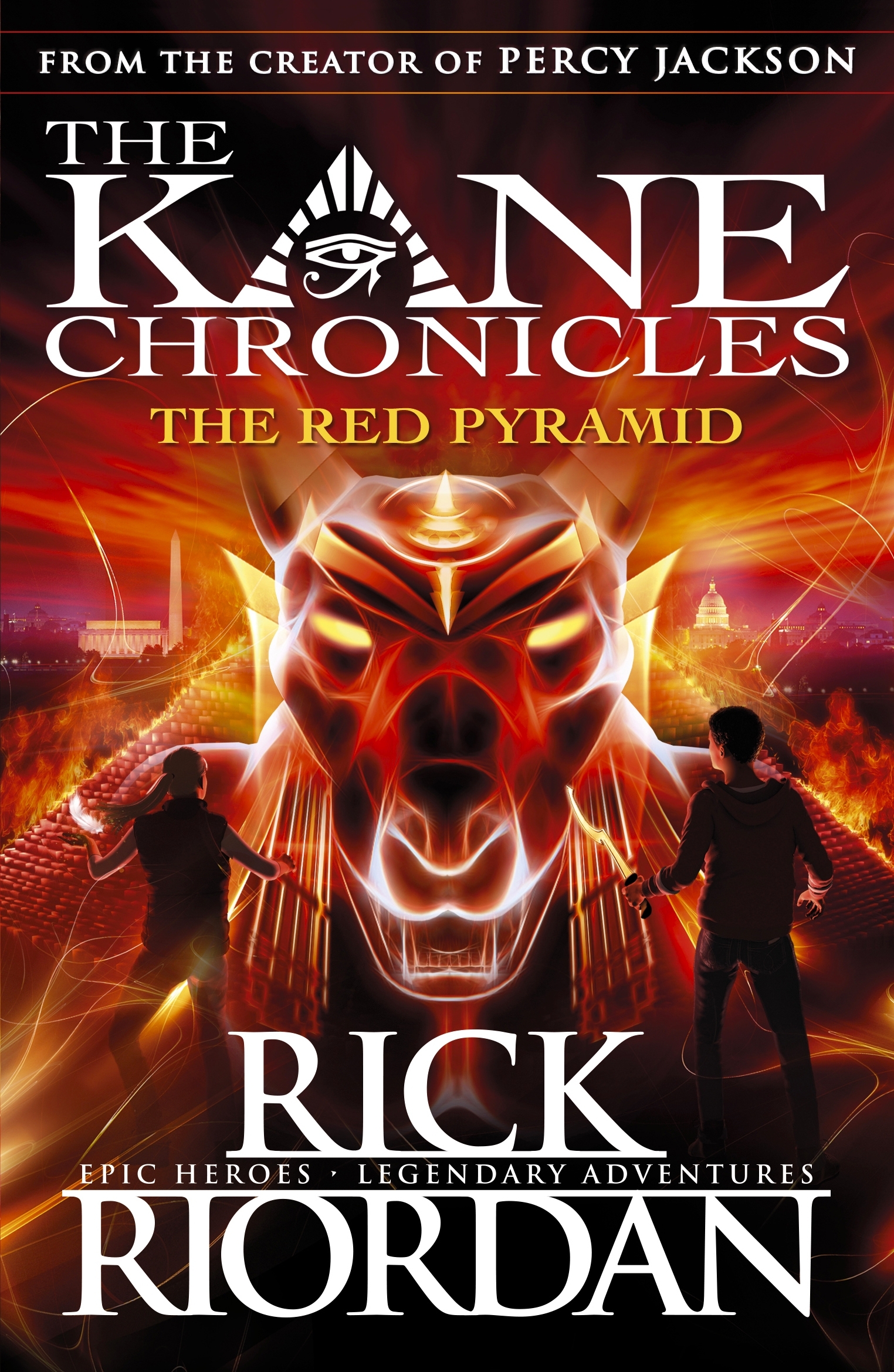 Image shows the cover of a children's novel, book 1 in The Kane Chronicles: The Red Pyramid by Rick Riordan. The cover illustration shows a boy and a girl in silhouette facing a dangerous looking sphinx like creature which is glowing red and yellow.