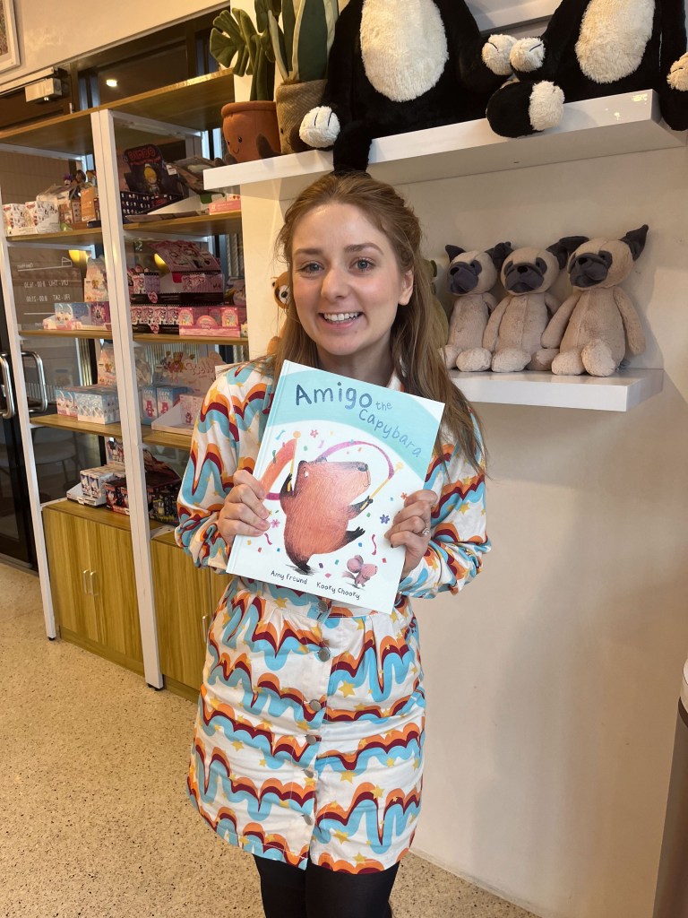 A photo of Amy Freund holding a picture book