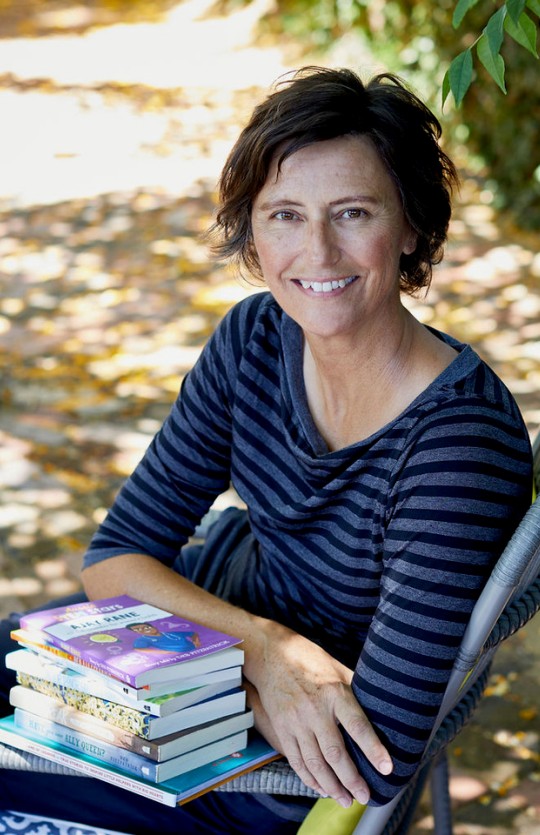 A photo of Deb Fitzpatrick and a stack of books