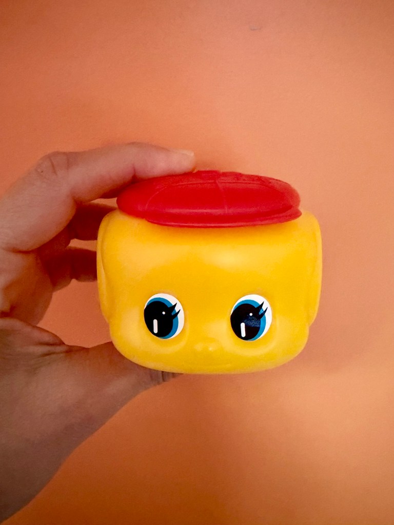 A container of glue shaped like a face.