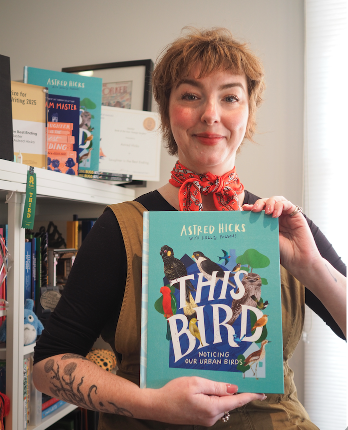 A photo of Astrid Hicks holding up her book This Bird.